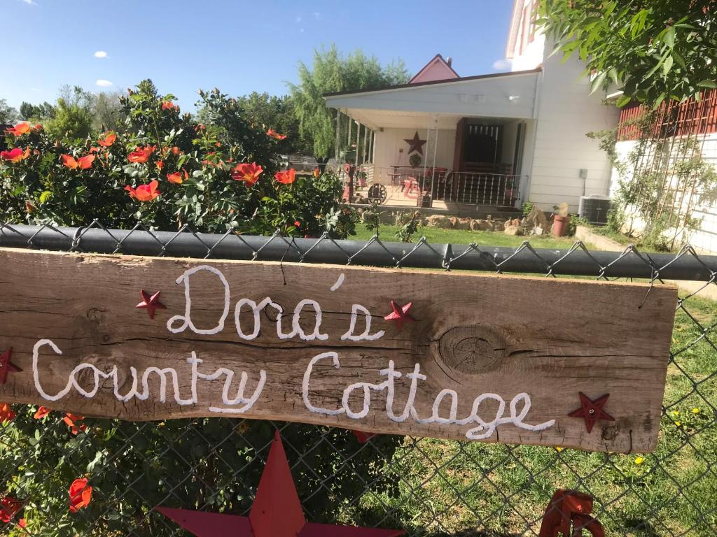 a sign on a fence in front of a yard at Dora's Country Cottage in Escalante