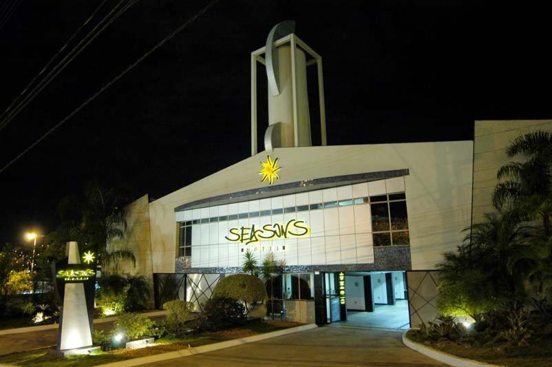 un bâtiment avec un panneau lumineux sur son côté dans l'établissement Motel Seasons, à Belo Horizonte