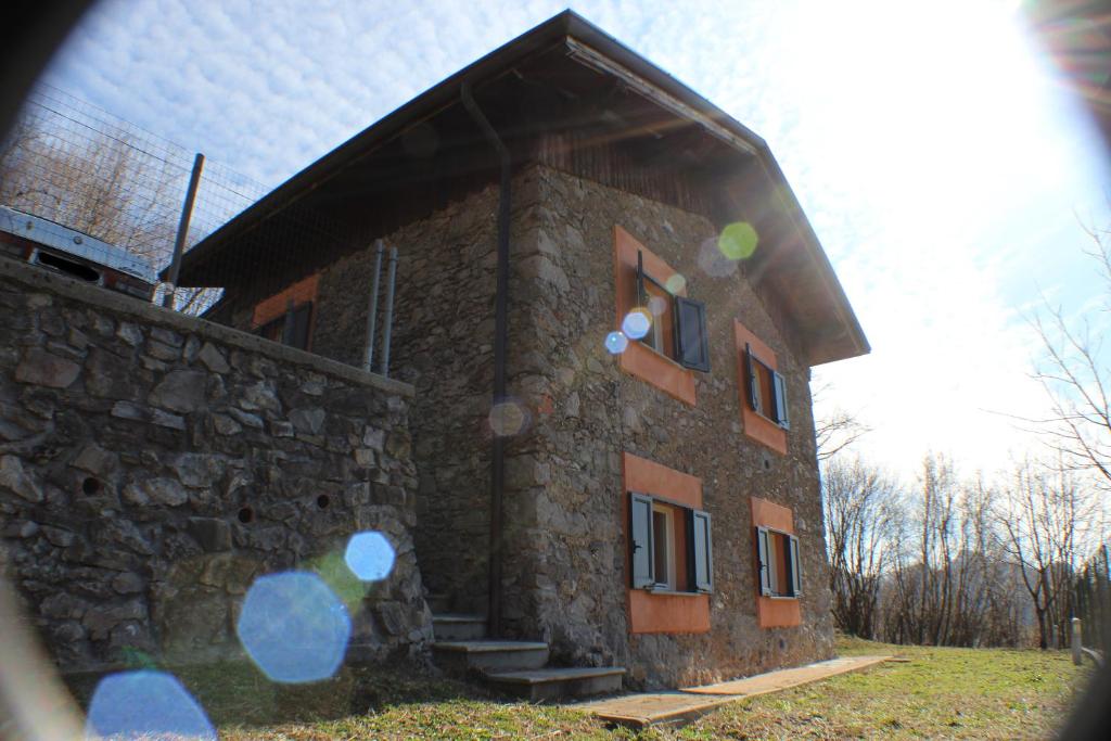 a small stone building with a stone wall at I laghi di Spettino in Antea