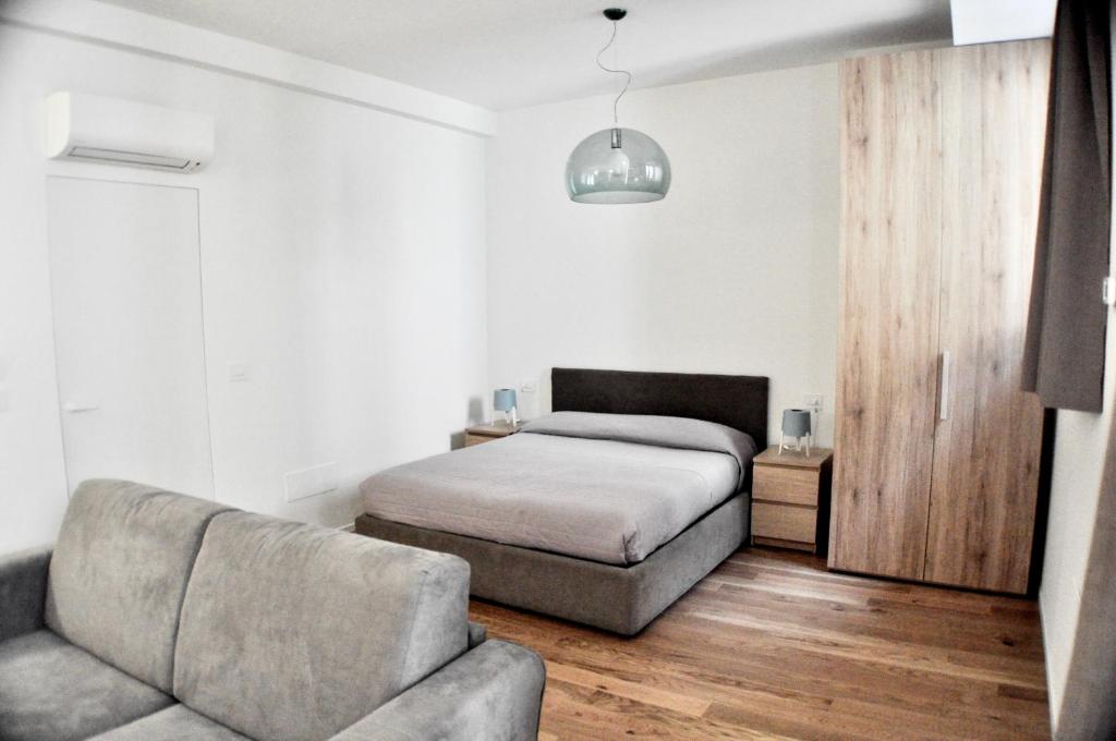 ein Schlafzimmer mit einem Bett und einem Sofa in der Unterkunft M Suite in San Benedetto del Tronto