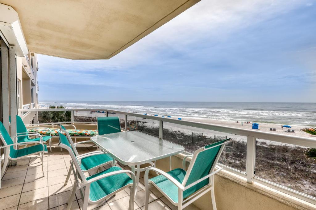 a balcony with a table and chairs and the beach at Enclave 304 in Orange Beach