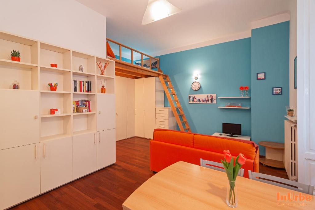 ミラノにあるInUrbe - Navigli Studioのリビングルーム(オレンジ色のソファ、階段付)