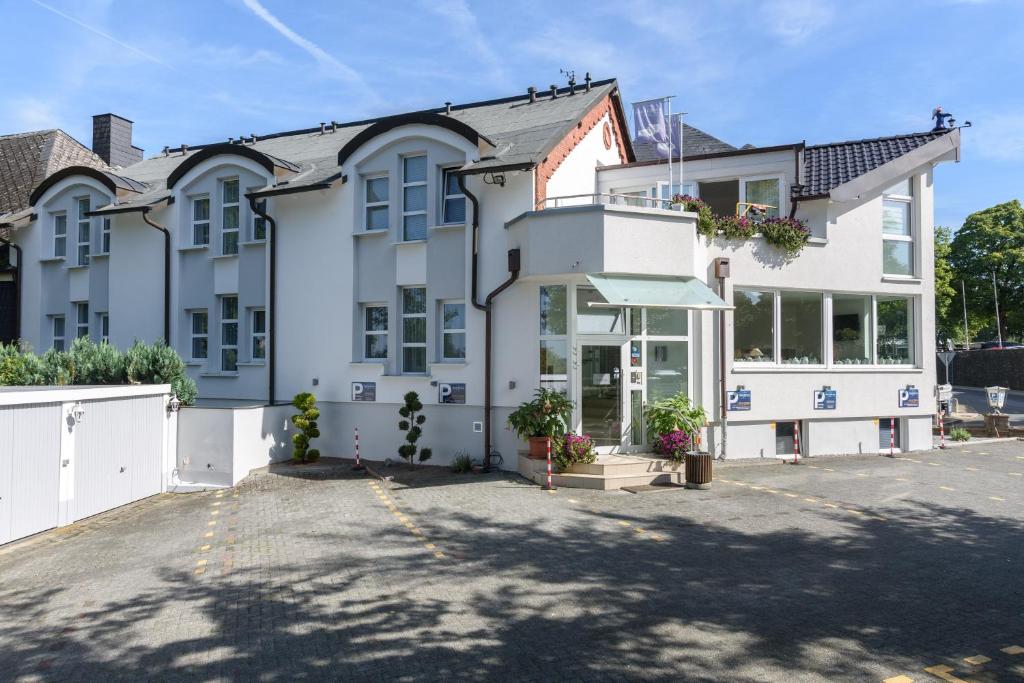 une grande maison blanche avec une allée. dans l'établissement Hotel Böving, à Breckerfeld