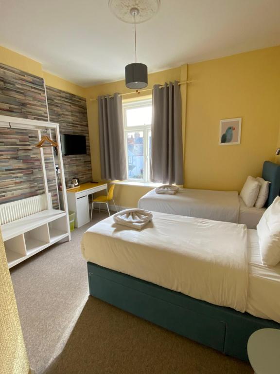 Habitación de hotel con 2 camas y escritorio en WiseStay, en Cardiff