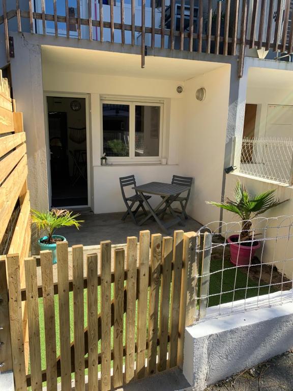 a wooden fence in front of a house with a table at Studio entre lac et océan à Hossegor in Soorts-Hossegor