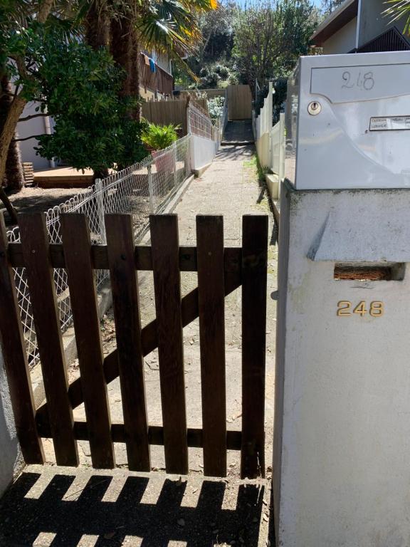 a wooden fence next to a sidewalk with a gate at Studio entre lac et océan à Hossegor in Soorts-Hossegor