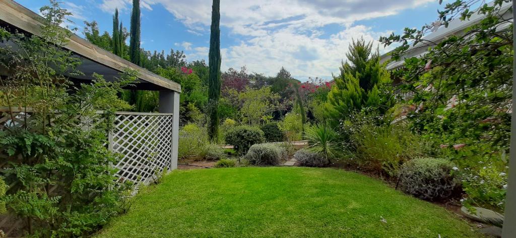 a garden with a white gate and green grass at Abigail's Garden Cottage in Montagu