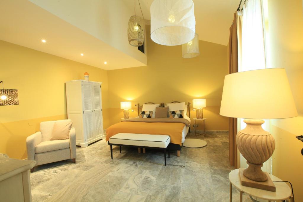 una camera con letto, sedia e lampada di Chambres D' hôtes Les Ormes a Saint-Rémy-de-Provence