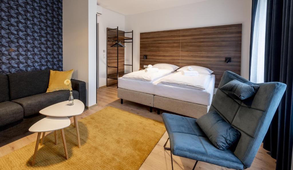 een hotelkamer met een bed en een bank bij Hotel Zu Freunden in Hamm