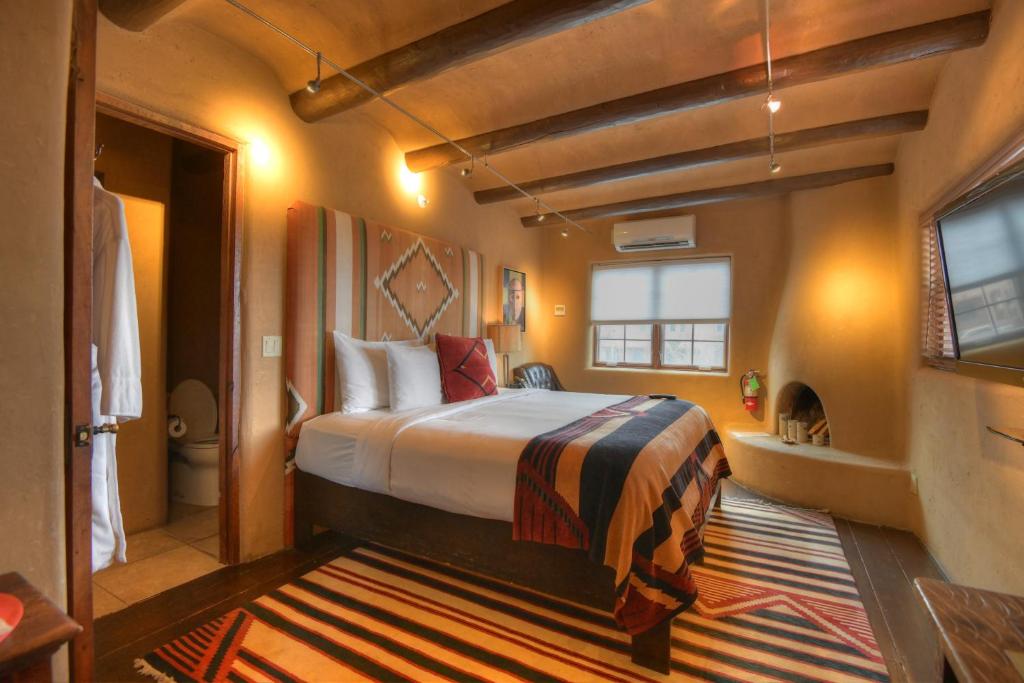 a hotel room with a bed and a bathroom at Inn at Vanessie in Santa Fe