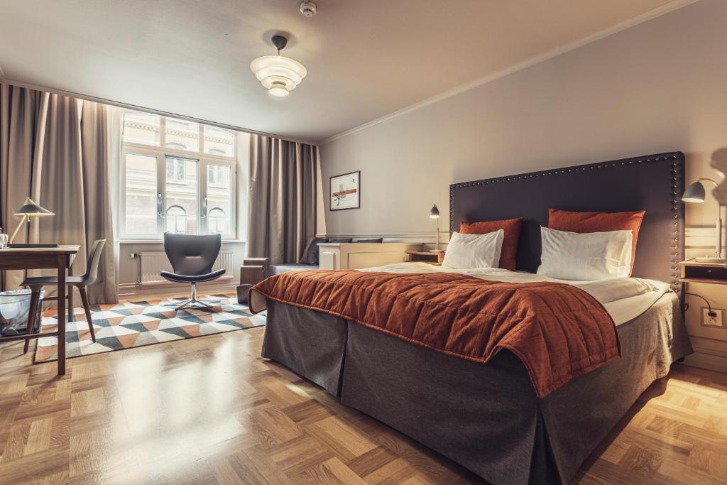 - une chambre avec un grand lit et un bureau dans l'établissement Hotel Poseidon, à Göteborg