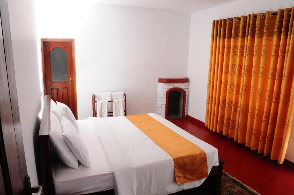 1 dormitorio con 1 cama grande y chimenea en Lassana Villa, en Nuwara Eliya