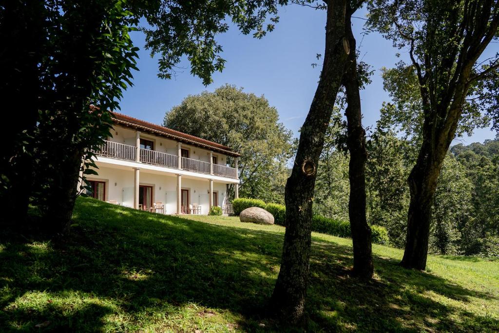 zewnętrzny widok na dom z drzewami w obiekcie Hotel Rural Quinta de Novais w mieście Arouca