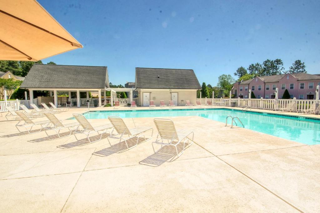 a swimming pool with lounge chairs in a resort at Two-Bedroom Vacation Condo in Myrtle Beach