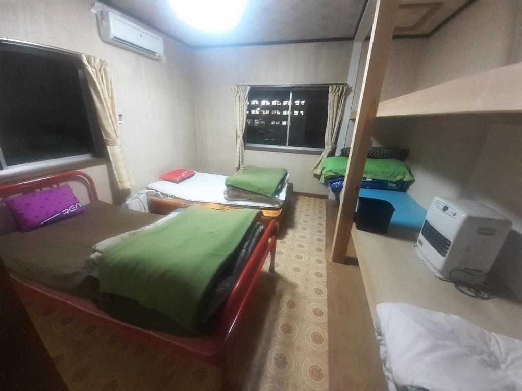 Zimmer mit 3 Etagenbetten und einem Fenster in der Unterkunft Hamburger restaurant Big foot / Vacation STAY 6626 in Hachinohe