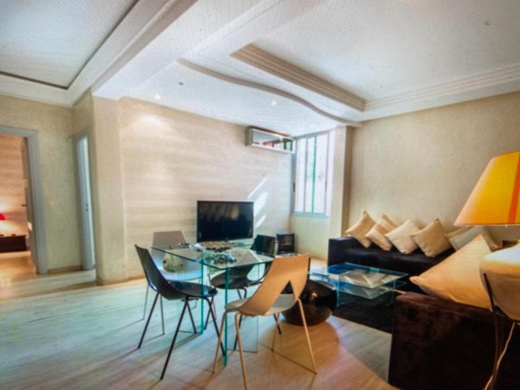 Una sala de estar con una mesa de cristal y un sofá. en Comme à la maison, en plein coeur de Marrakech, en Marrakech