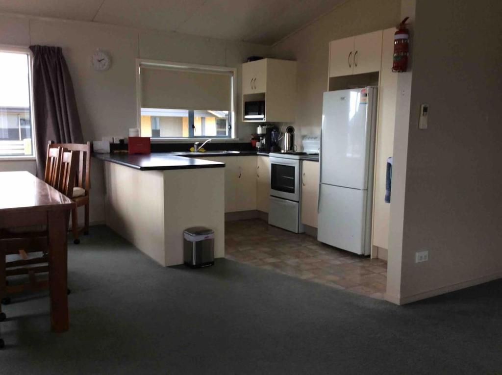 a kitchen with a white refrigerator and a table at Irishman Retreat in Twizel