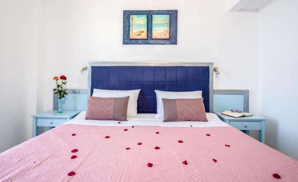 a bedroom with a bed with red roses on it at Klima Rooms in Palaiochóra