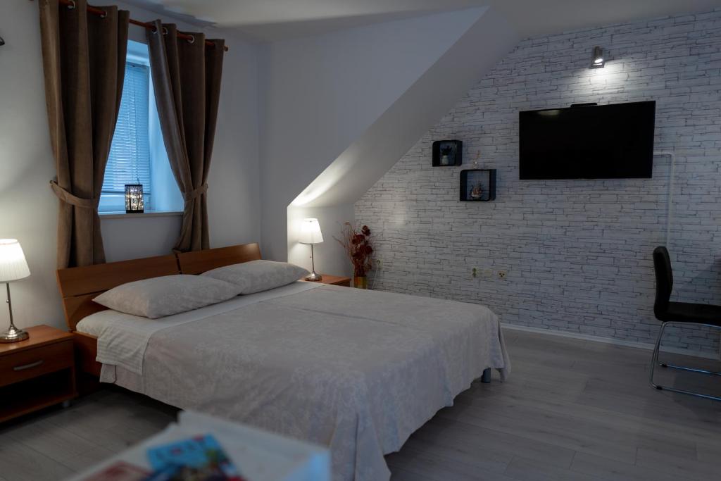 1 dormitorio con cama y pared de ladrillo en Studio Banovac en Dubrovnik