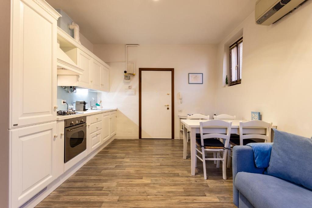 cocina y comedor con mesa y sofá azul en Casa Fischer 2, en Mantua