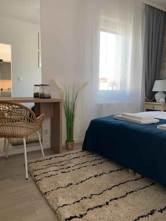 um quarto com uma cama, uma cadeira e um tapete em Apartament w Centrum em Słupsk
