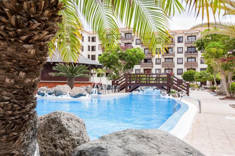 une piscine avec un pont et un bâtiment dans l'établissement Apartamento Katrina Balcón del mar, à Costa del Silencio