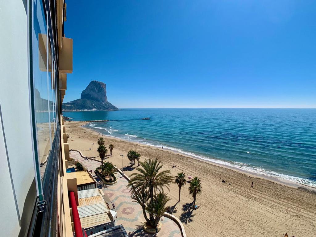 a view of a beach with palm trees and the ocean at Edf CalpeMar, planta 8 - primera linea in Calpe