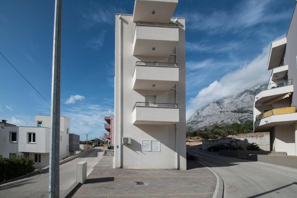 - un bâtiment avec balcon sur le côté d'une rue dans l'établissement International apartment Radic, à Makarska
