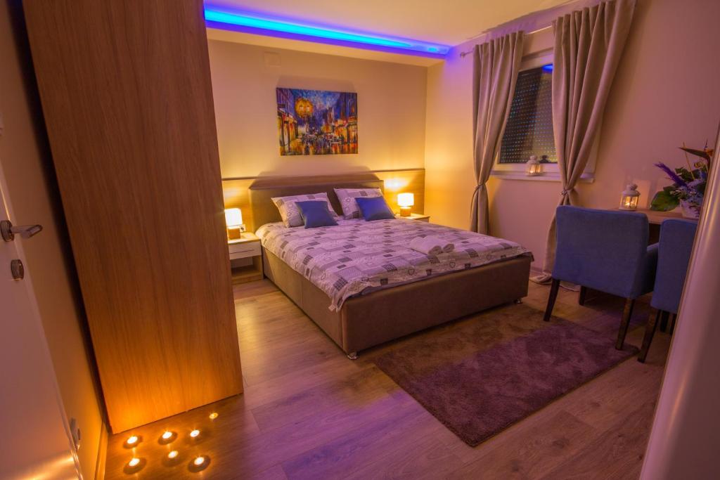 1 dormitorio con 1 cama con edredón morado en Gradiska na Savi apartmani i sobe en Bosanska Gradiška