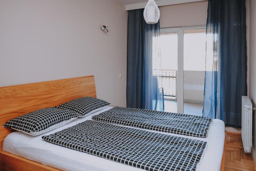 een bed met 2 kussens in een kamer met een raam bij HEDONA in Visoko