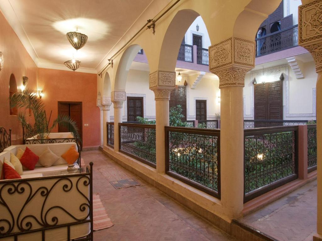een veranda met een bank en een balkon bij Riad Sidi Ayoub in Marrakesh
