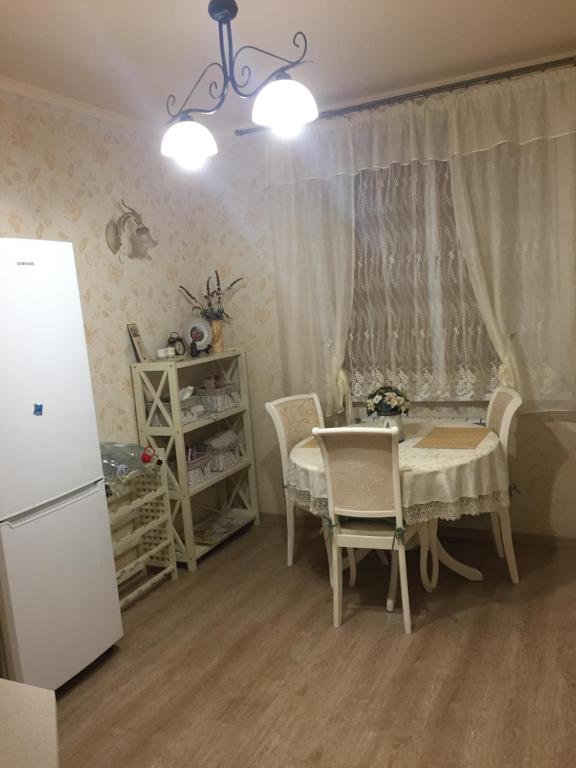 a kitchen with a table and chairs and a refrigerator at Красивая 2-ком.кв.,в Новом доме!От хозяйки! in Odesa