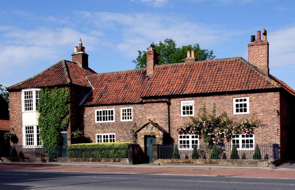 una casa de ladrillo rojo con techo rojo en Porch House, en Northallerton