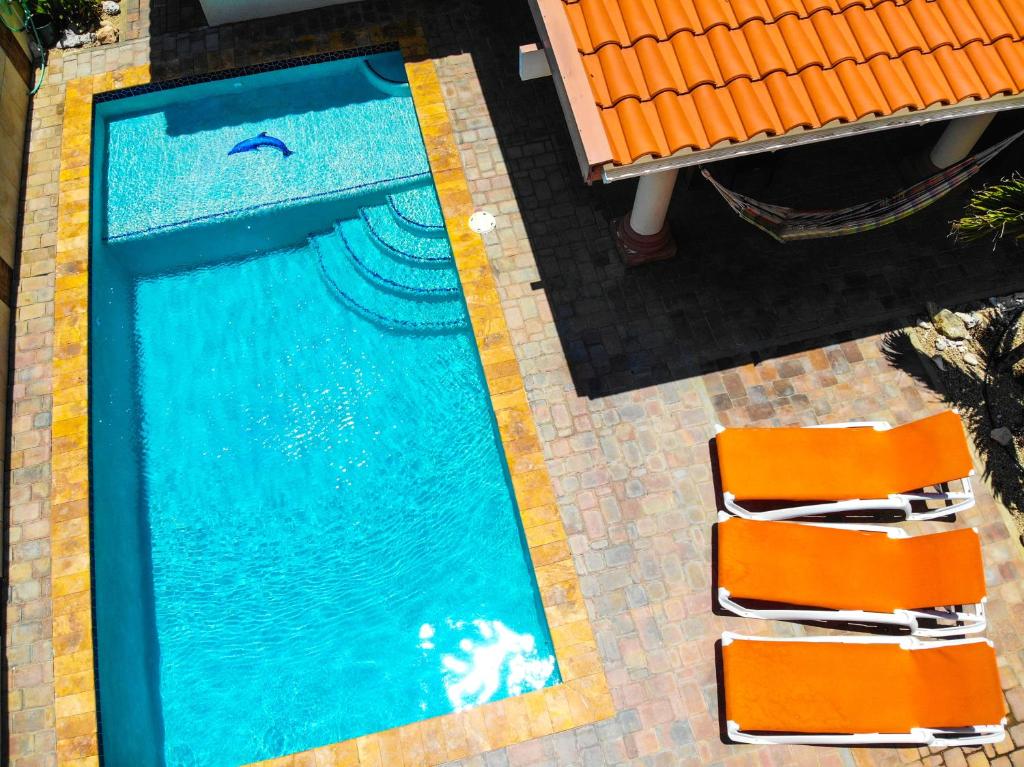 an overhead view of a swimming pool with two orange chairs at Villa Swiss Paradise with private pool in Palm-Eagle Beach