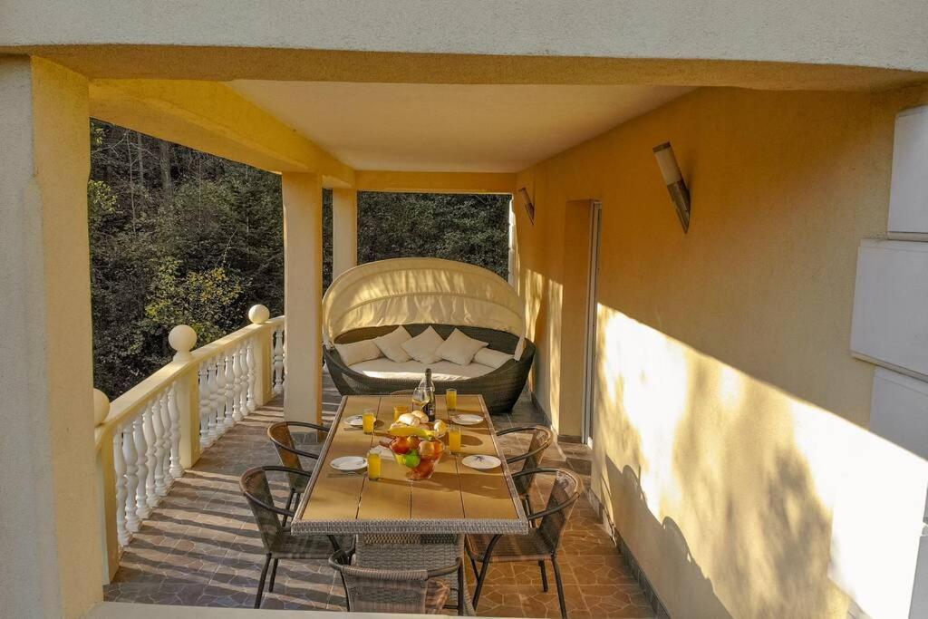 a porch with a table and chairs on a balcony at Kuća za odmor „VILLA MARIJA” in Kostel