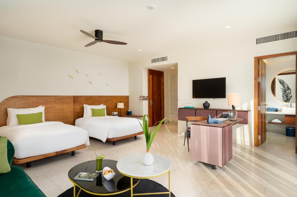 a hotel room with two beds and a tv at The Aviary Hotel in Siem Reap