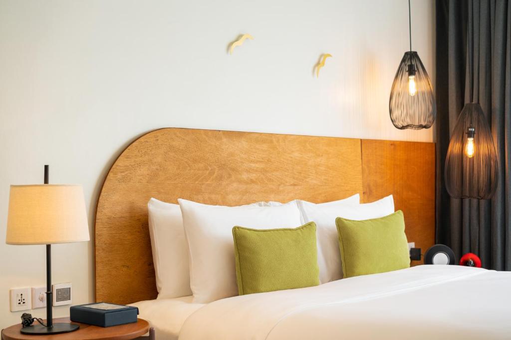 a bedroom with a large bed with a wooden headboard at The Aviary Hotel in Siem Reap