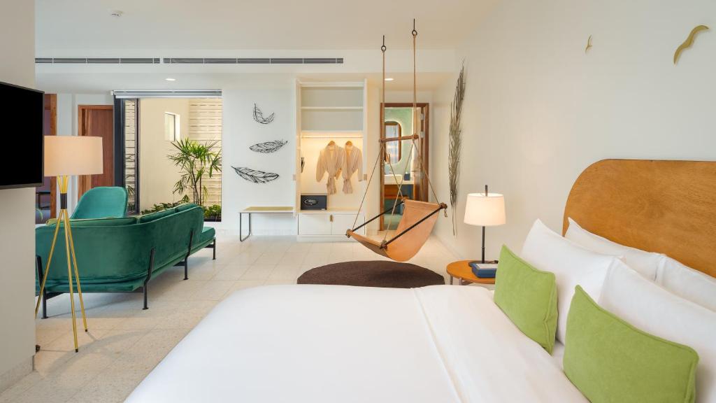 a bedroom with a bed and a living room at The Aviary Hotel in Siem Reap