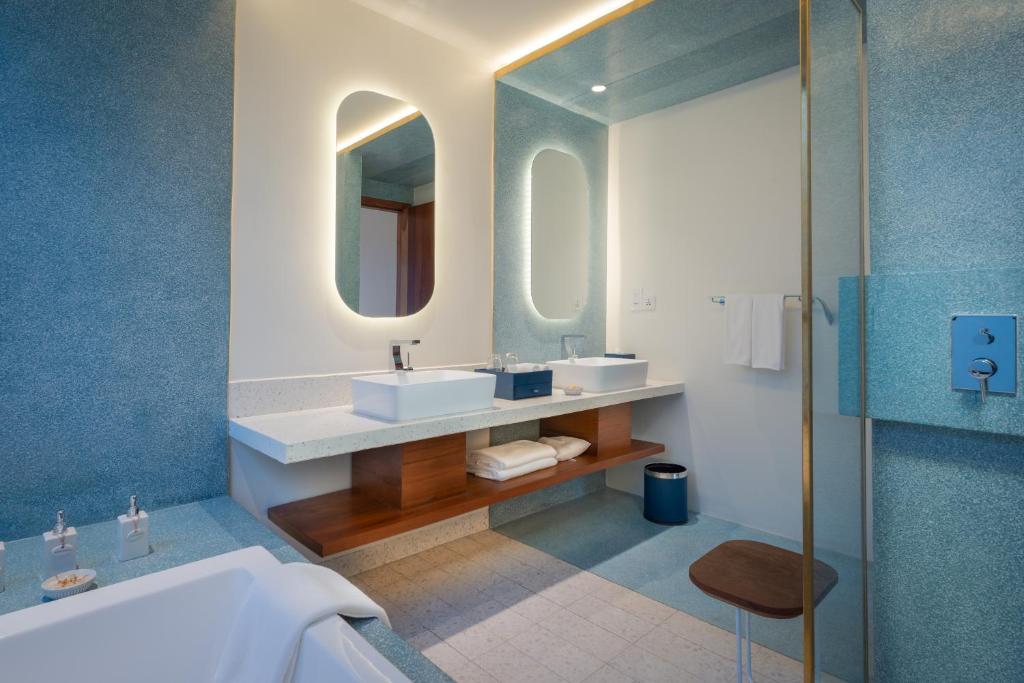 a bathroom with two sinks and a mirror at The Aviary Hotel in Siem Reap