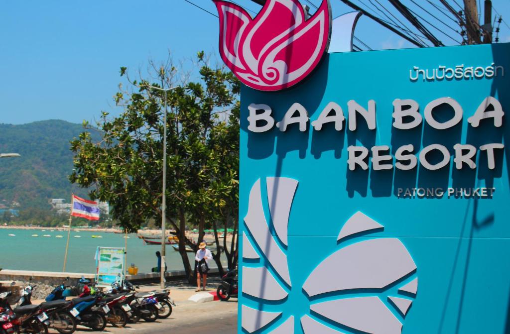 a sign for a baran boat resort with a group of motorcycles at Baan Boa Resort in Patong Beach