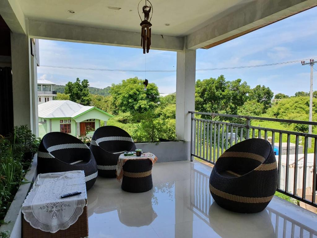 a porch with two chairs and a table on a balcony at WLA Homestay in Labuan Bajo