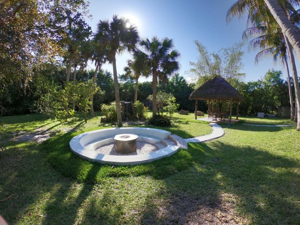 een park met een fontein in het gras met palmbomen bij JUPITER WATERFALLS - NEWLY UPDATED - TIKI HUT, FIRE PIT, KITCHEN, POOL HEATER and MORE in Jupiter