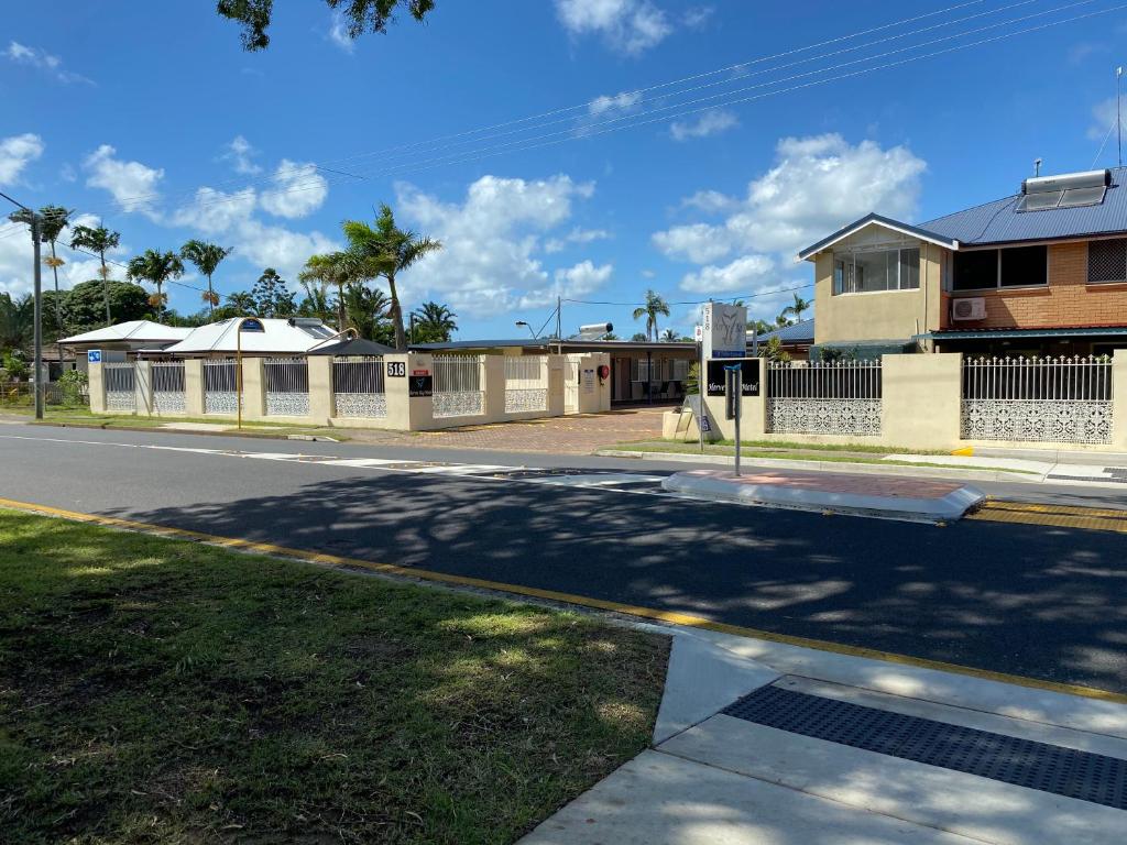 an empty street with a house and a building at Hervey Bay Motel in Hervey Bay