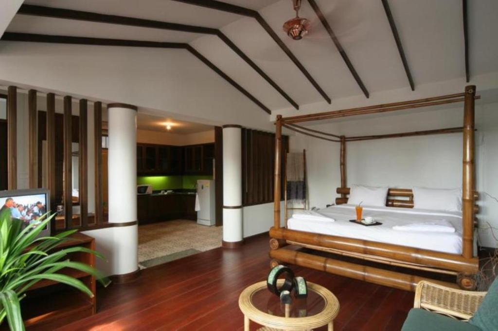 a bedroom with a large bed and a living room at Keerati Homestay in Pattaya Central