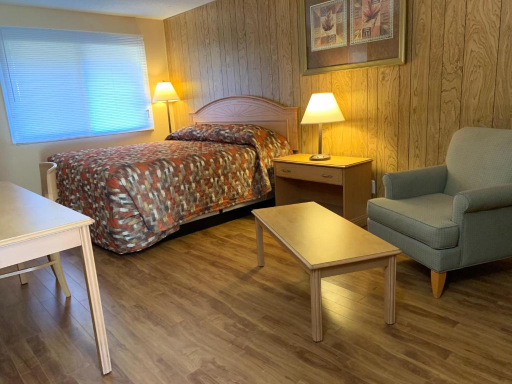 a hotel room with a bed and a chair at Green View Motel and RV Park in Greenwood