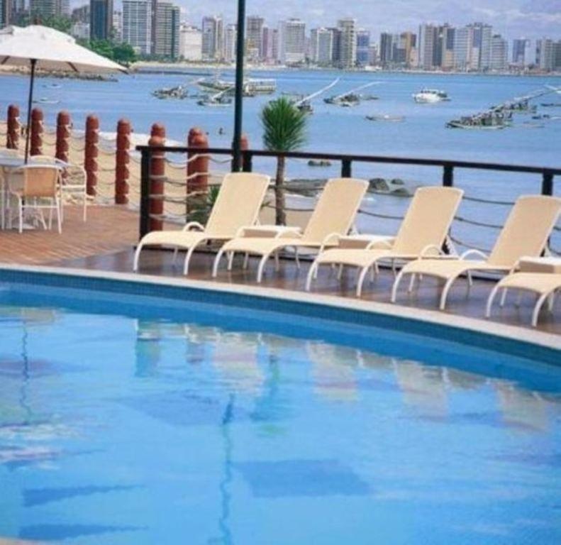 a group of chairs sitting next to a swimming pool at Flat Iate in Fortaleza