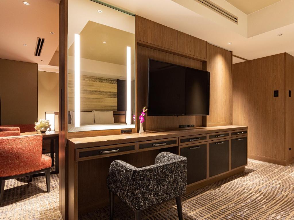 a hotel room with a television and a chair at Hotel Nikko Fukuoka in Fukuoka