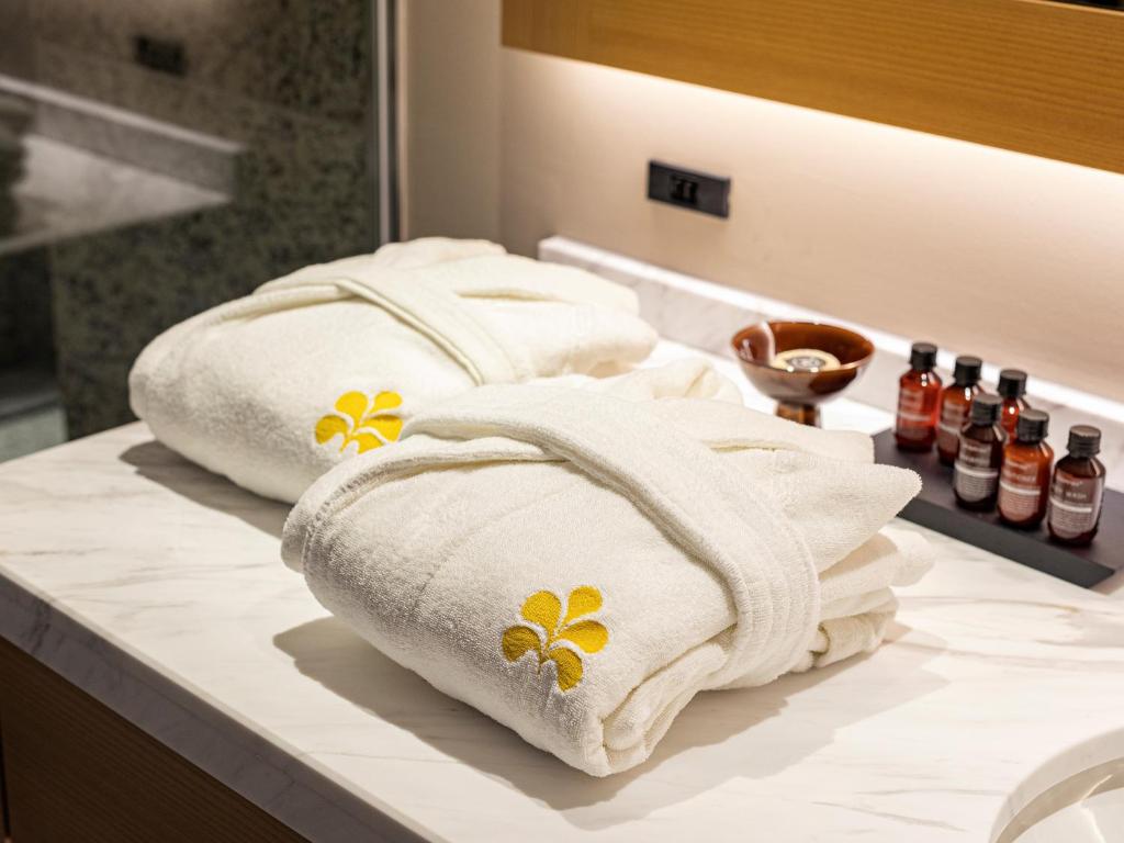 two towels with flowers on them sitting on a bathroom counter at Hotel Nikko Fukuoka in Fukuoka