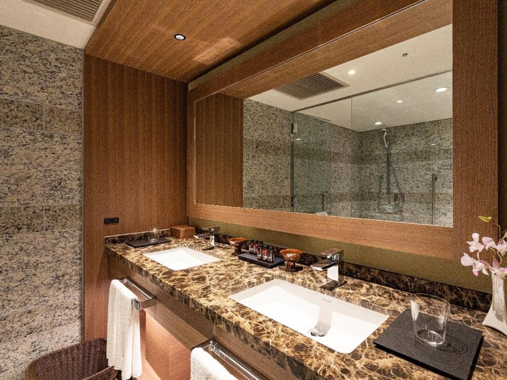 a bathroom with two sinks and a large mirror at Hotel Nikko Fukuoka in Fukuoka