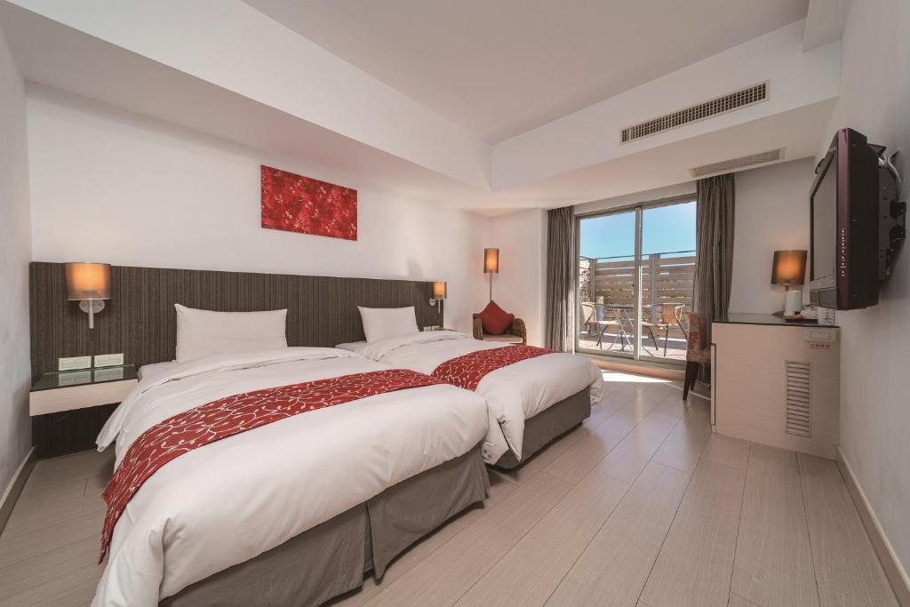 Cette chambre comprend deux lits et une grande fenêtre. dans l'établissement Fish Hotel Hualien, à Hualien